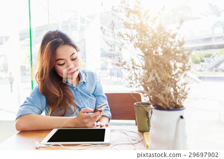 Asian woman using telephone in coffee shop 29697902