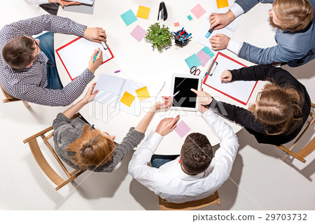 Team Sitting Behind Desk Checking Reports Stock Photo 29703732