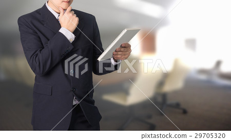 Confident Asian businessman reading notebook Confident Asian businessman reading notebook 29705320
