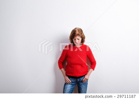 Senior woman in red sweater, hands in pockets 29711187