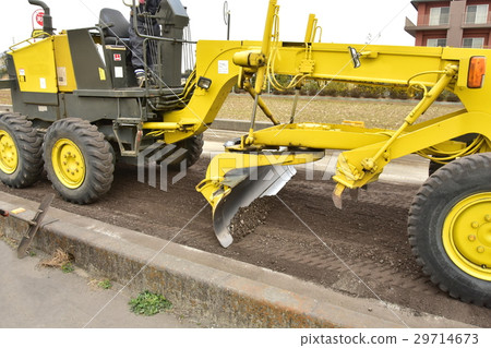 A motor grader dropping a blade and leveling the road A motor grader dropping a blade and leveling the road 29714673