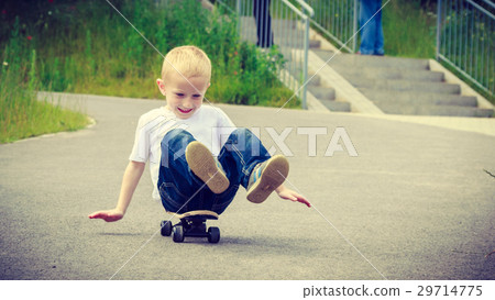 Child kid sitting on skateboard having fun outdoor Child kid sitting on skateboard having fun outdoor 29714775