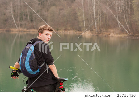 Young man on mountain bike relaxes 29719436