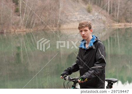 Young man on mountain bike relaxes Young man on mountain bike relaxes 29719447