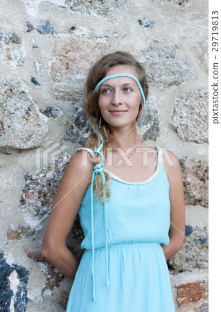 woman standing with medieval stone walls behind 29719813
