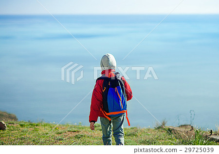 Child standing in front of a seascape 29725039