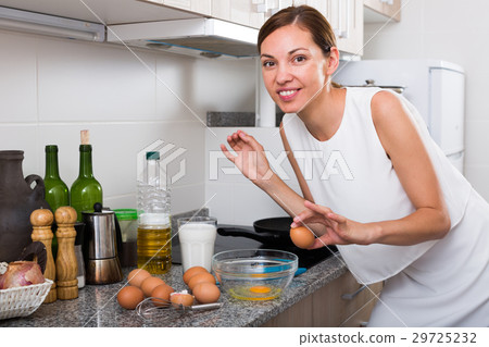 woman preparing omelet 29725232