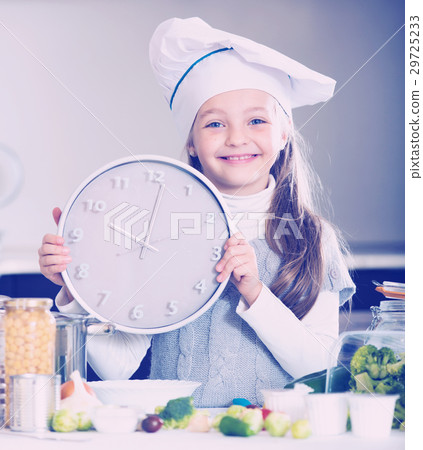 Portrait of sweet little girl with veggies and clock 29725233