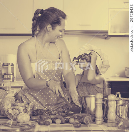 Little girl with mom at kitchen. 29726428