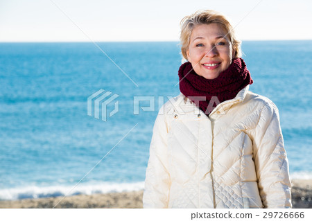 Mature woman walking by sea 29726666