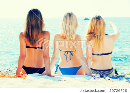 Girls wearing swimwear sitting back-first Girls wearing swimwear sitting back-first 29726728
