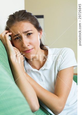 Upset girl on sofa at home Upset girl on sofa at home 29726845