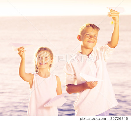 two kids playing paper planes 29726846