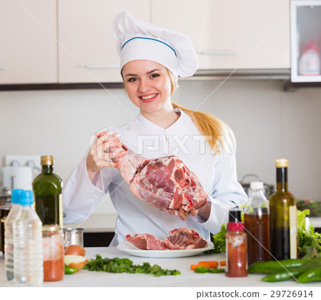Female chef preparing lamb parts at kitchen table Female chef preparing lamb parts at kitchen table 29726914