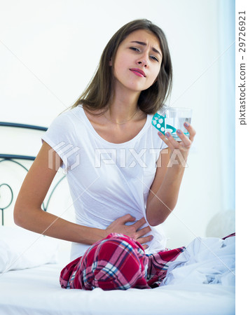 Teenage girl having belly pain and taking pills Teenage girl having belly pain and taking pills 29726921