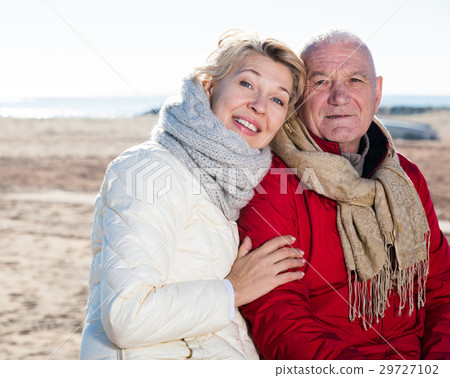Mature couple sitting by sea 29727102