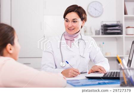 Doctor fills patient card for girl Doctor fills patient card for girl 29727379