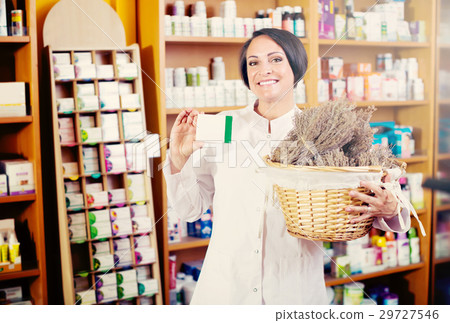 woman with bunch of dried herbs in drugstore . woman with bunch of dried herbs in drugstore . 29727546