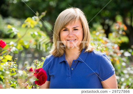 portrait of mature woman in garden on summer day. 29727866