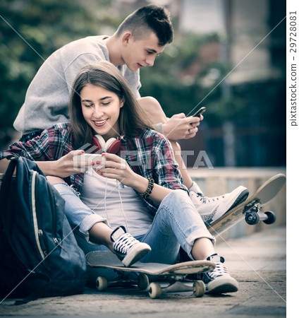 Teenage relaxing with mobile phones Teenage relaxing with mobile phones 29728081