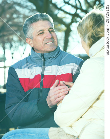Husband and wife sitting on park bench Husband and wife sitting on park bench 29728105
