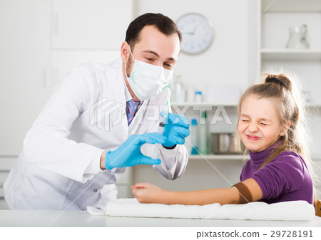 Young doctor ready to make injection to visitor Young doctor ready to make injection to visitor 29728191