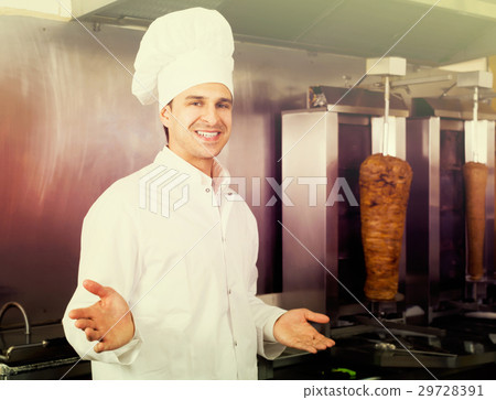 Positive arabian cook posing near meat for kebab Positive arabian cook posing near meat for kebab 29728391