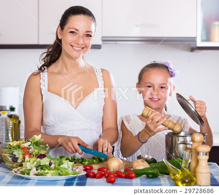 woman and little girl cooking vegetables woman and little girl cooking vegetables 29728686