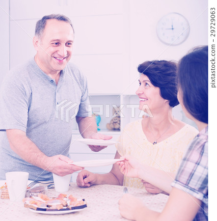 senior man serving family lunch at home . senior man serving family lunch at home . 29729063