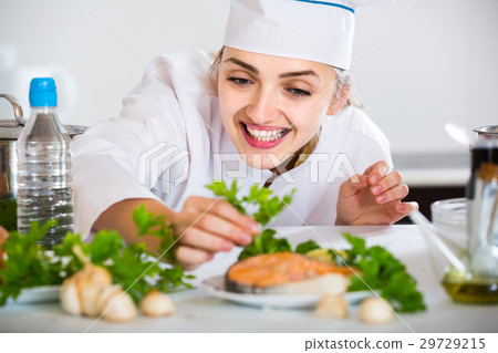 young cook with prepared salmon in professional kitchen young cook with prepared salmon in professional kitchen 29729215