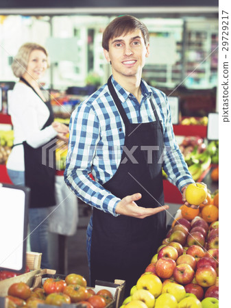 Senior woman and young man offering seasonal fruits 29729217