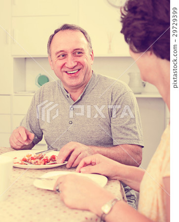 Happy mature man eating lunch and listening to woman Happy mature man eating lunch and listening to woman 29729399