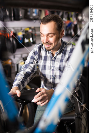 Biker is looking for bicycle saddles 29729403