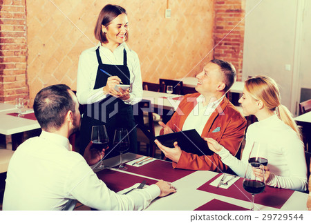 Positive female waiter writing down order Positive female waiter writing down order 29729544
