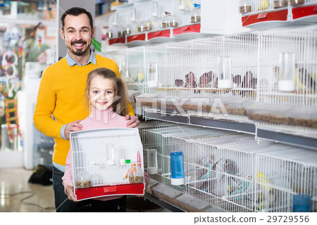 Father and daughter enjoying their purchase of canary bird in pet shop 29729556