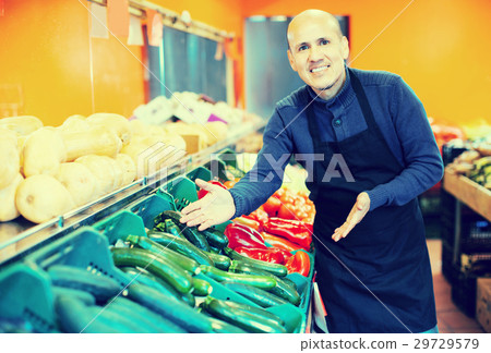 Salesman posing near different vegetables Salesman posing near different vegetables 29729579