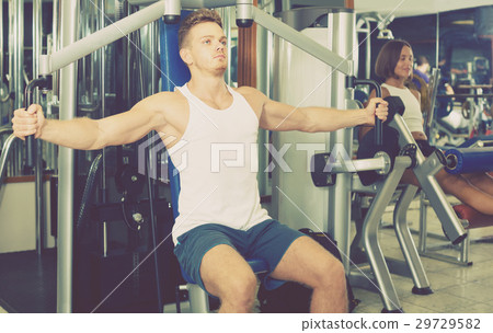 well trained man using pec deck gym machinery indoors well trained man using pec deck gym machinery indoors 29729582