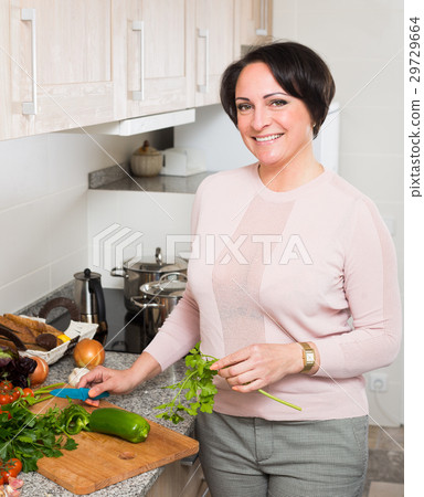 Positive housewife cooking veggies at home Positive housewife cooking veggies at home 29729664