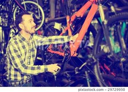 Man considers bicycle frame in store 29729930