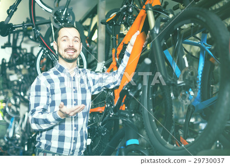 Man in sports workshop mounts bike using special tools 29730037