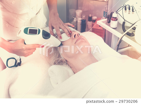 Aged woman making beauty procedures for face in spa salon 29730206