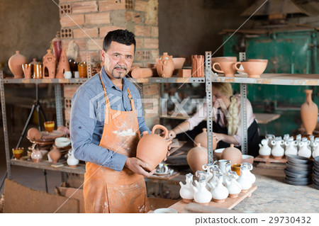 Positive male artisan having ceramics in hands Positive male artisan having ceramics in hands 29730432