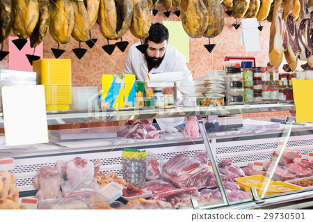 Smiling man seller showing meat Smiling man seller showing meat 29730501