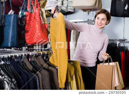 Adult woman choosing turtleneck sweater 29730505