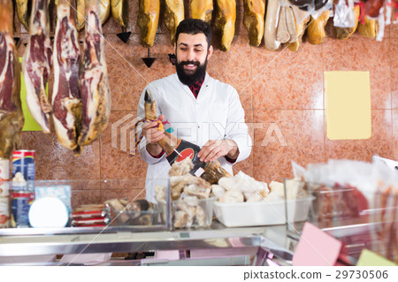 Male seller showing jamon 29730506