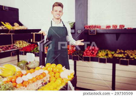 Young man seller displaying assortment Young man seller displaying assortment 29730509
