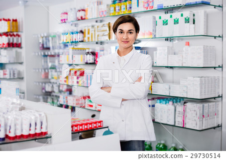 Female pharmacist arranging displayed assortment 29730514