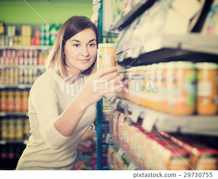 Cheerful female shopper searching for baby food 29730755