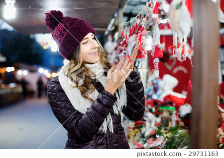 Positive young woman buying Christmas decoration Positive young woman buying Christmas decoration 29731163