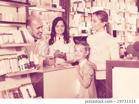 Two pharmacists helping customers 29731313